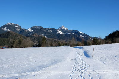 Scenic view of snowcapped mountains against clear blue sky