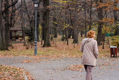 Rear view of woman walking on road