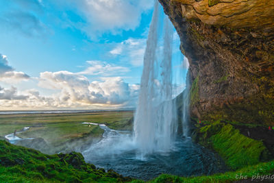 Scenic view of waterfall against sky