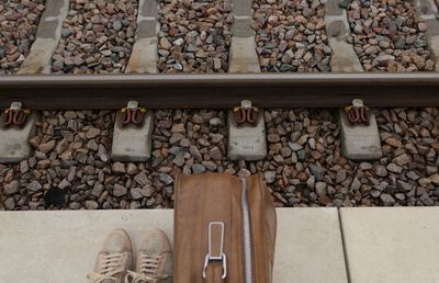 Low section of man by luggage at railroad platform