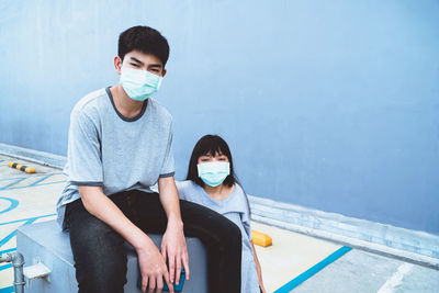 Portrait of cute sibling wearing mask outdoors