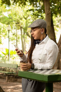 Young man using mobile phone while sitting outdoors