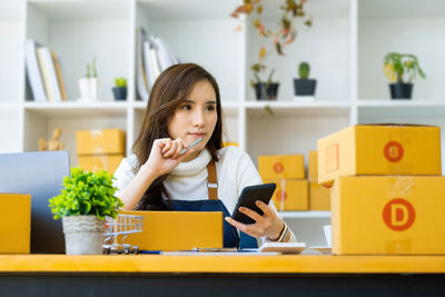 Side view of young woman sitting at home