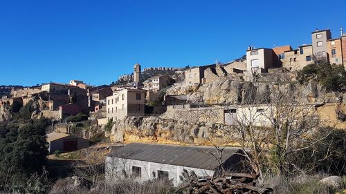 Low angle view of buildings against clear blue sky