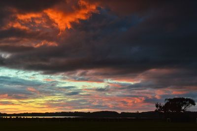 Scenic view of dramatic sky over silhouette landscape