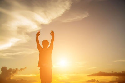 Low angle view of silhouette woman standing against sky during sunset