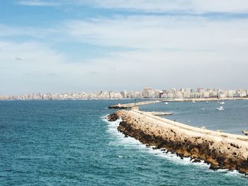 Scenic view of sea by city against sky