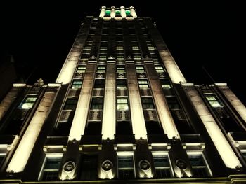 Low angle view of illuminated building against sky at night