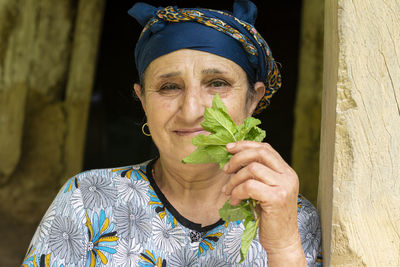 Portrait of smiling senior woman holding vegetable