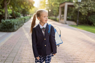 Full length of teenage girl standing on footpath