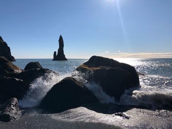 Rocks on beach against sky