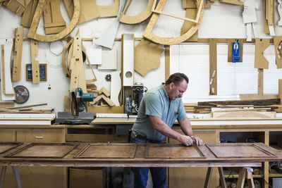 Carpenter polishing wood while working at workshop