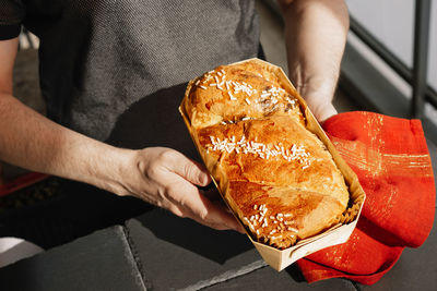 Midsection of man holding baked bread