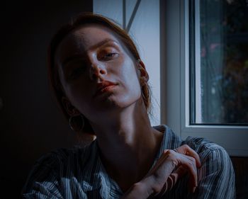 Portrait of a young woman looking away at home