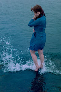 Young girl on a background of the sea in a blue dress, portrait