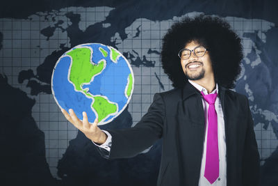 Man with umbrella standing against the wall