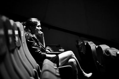 Side view of woman watching a movie in a cinema