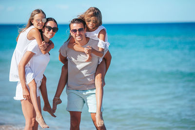 Portrait of friends standing at beach