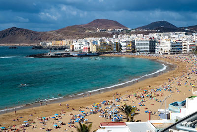 High angle view of beach by city against sky