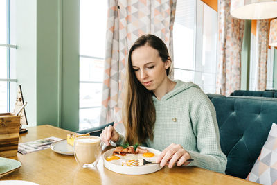 Young woman sitting on table