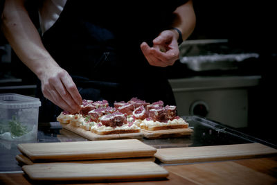 Midsection of man preparing food in kitchen