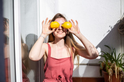 Young woman holding fruits while standing against outdoors