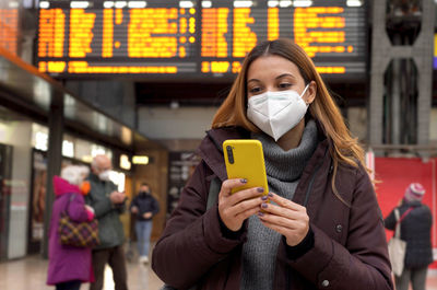 Young business woman wearing kn95 ffp2 face mask at train station