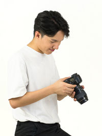 Young man taking selfie against white background