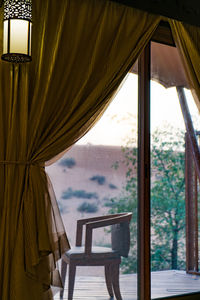 Side view of empty chair seen through window