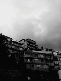 Low angle view of buildings against cloudy sky