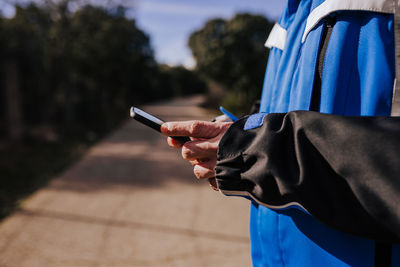 Midsection of man using phone outdoors