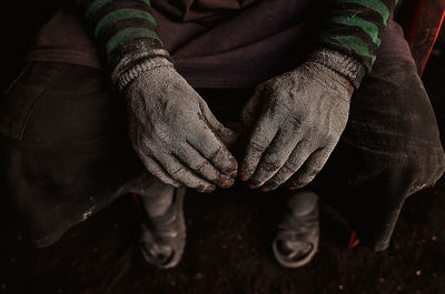 Low section of man with messy hands sitting on seat