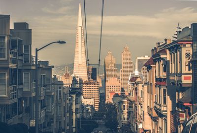 Buildings in city against cloudy sky