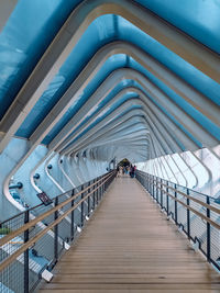 Rear view of man walking on footbridge