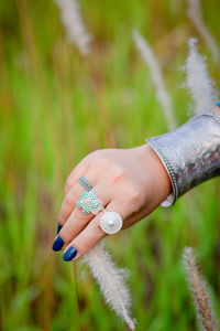 Midsection of woman hand holding plant on field