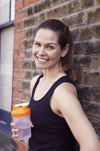 Young woman in sports clothes with bottle of water