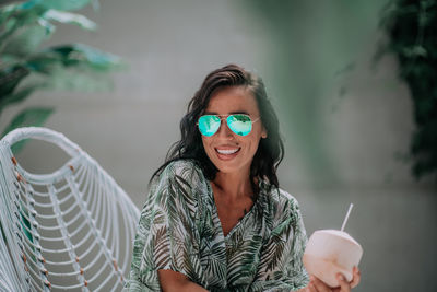 Portrait of smiling young woman sitting outdoors