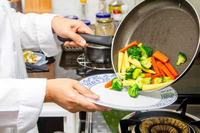 Midsection of woman preparing food in kitchen at home