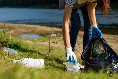 Low section of woman picking garbage