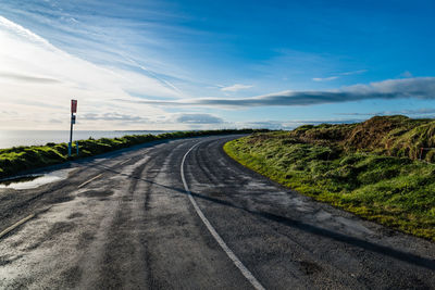 Road by landscape against sky