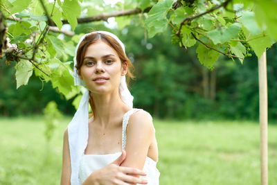 Portrait of young woman standing on field