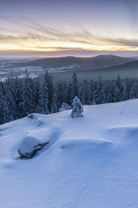 Scenic view of snow covered landscape against sky during sunset