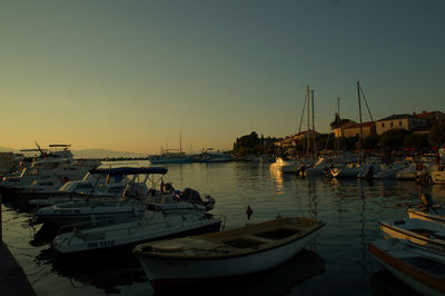 Boats in harbor at sunset