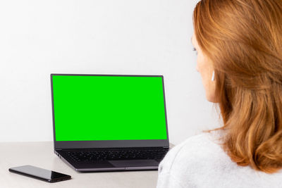 Rear view of woman using laptop