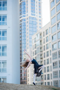 Side view of woman against buildings in city