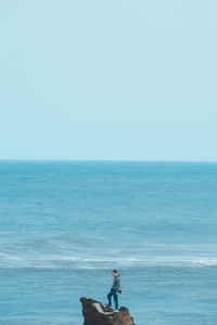 Men on beach against clear sky