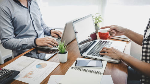 Midsection of colleagues working at office