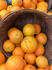 High angle view of oranges in basket for sale at market stall