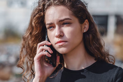 Beautiful young woman talking on phone outdoors