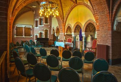 Empty chairs and tables in illuminated building